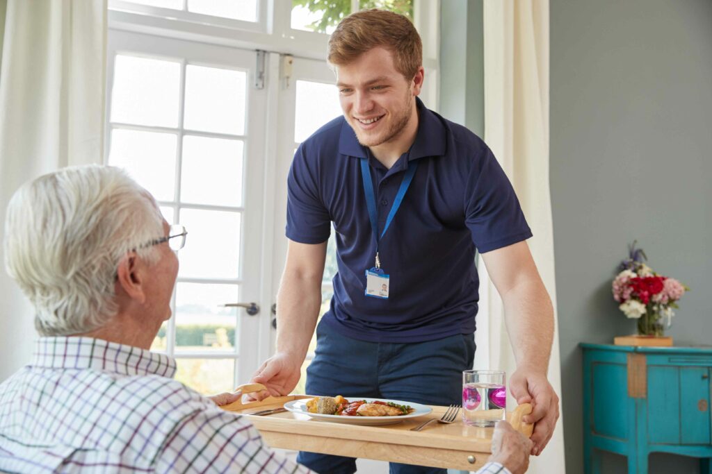 Altenpfleger Hilft Patien beim essen ASG Pflege GmbH